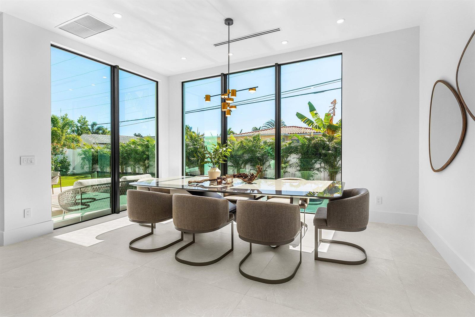 A modern dining room features a glass table, six upholstered chairs, and floor-to-ceiling windows — 435 NE 15th Terrace, Boca Raton FL 33432, BOCA RATON, FL