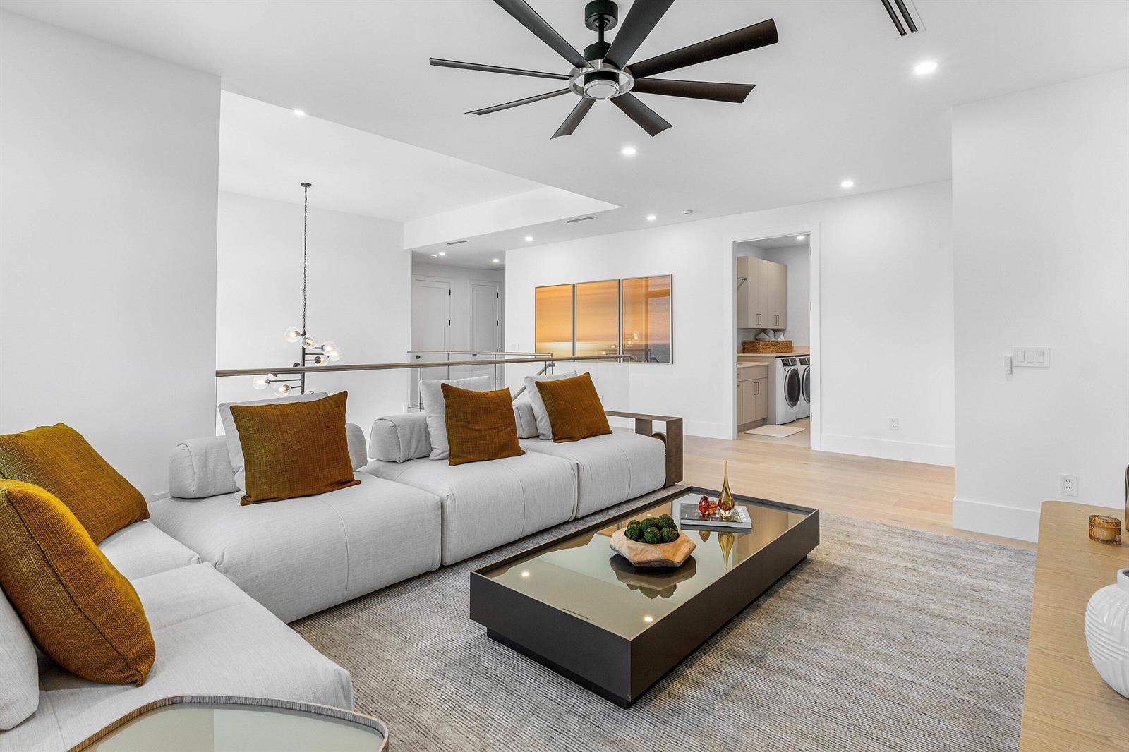 A modern living room features a light gray sectional sofa, a glass coffee table, and a ceiling fan — 435 NE 15th Terrace, Boca Raton FL 33432, BOCA RATON, FL