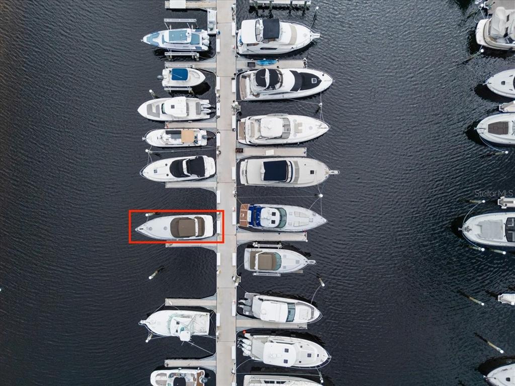 An aerial view shows a marina with numerous boats docked along a central pier — 102 RIVIERA DUNES WAY UNIT N-29, PALMETTO, FL