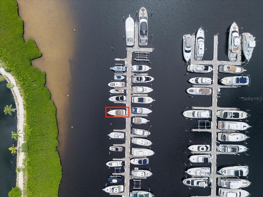 An aerial view shows a marina with numerous boats docked in slips along two piers — 102 RIVIERA DUNES WAY UNIT N-29, PALMETTO, FL