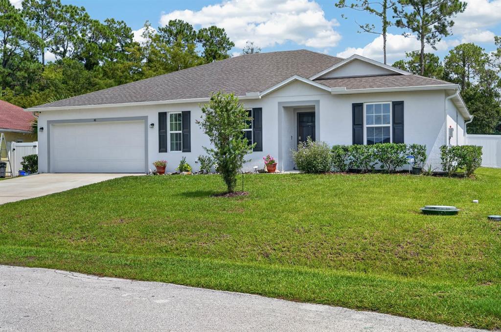 A single-story white house with a two-car garage and a front lawn — 48 PORCUPINE DRIVE, PALM COAST, FL
