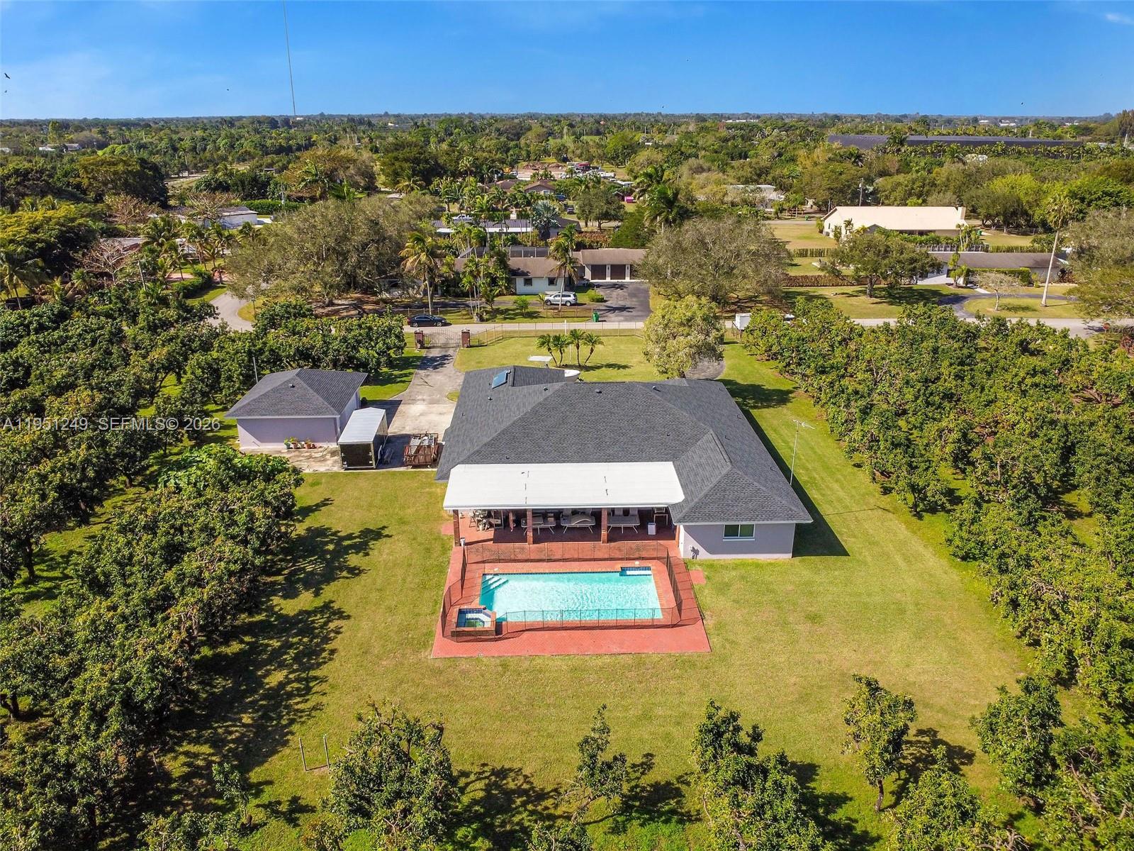 An aerial view shows a house with a pool, patio, and detached garage on a lot — 23505 SW 153rd Ave, Homestead FL 33032, HOMESTEAD, FL