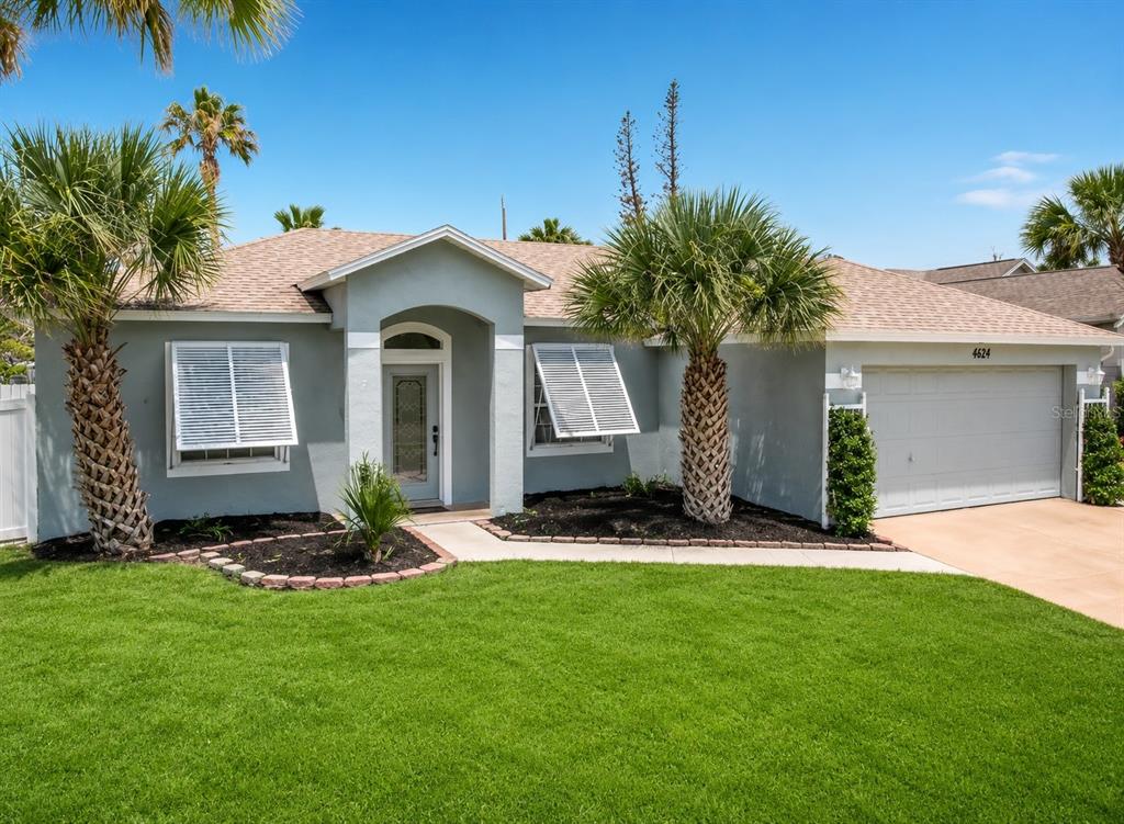 A single-story house with a gray exterior, white shutters, palm trees, and a two-car garage — 4624 S ATLANTIC AVENUE, NEW SMYRNA BEACH, FL