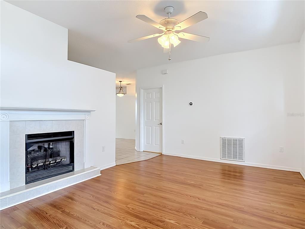 A living room features a fireplace, ceiling fan, and hardwood floors — 4624 S ATLANTIC AVENUE, NEW SMYRNA BEACH, FL