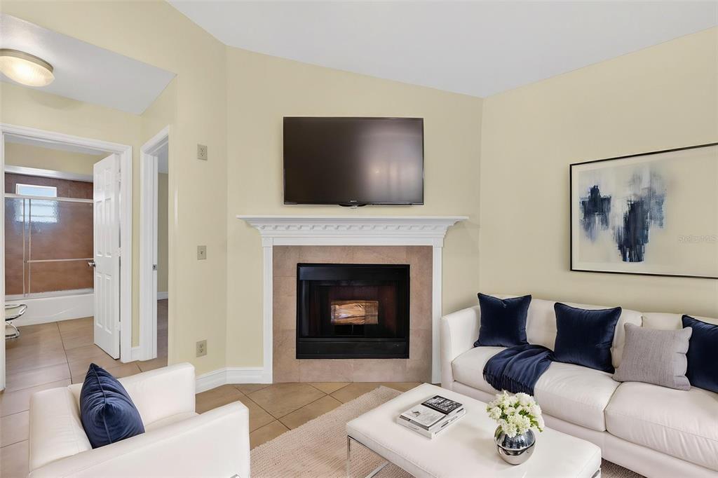 A living room features a fireplace with a mounted television, white sofa, and tile flooring — 3633 JERICHO DRIVE, CASSELBERRY, FL