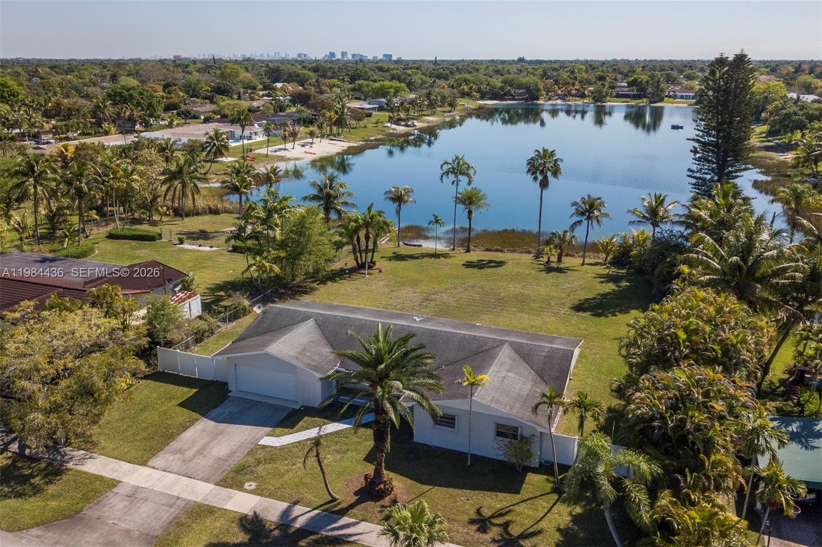 An aerial view shows a single-story house with a large backyard overlooking a lake — 11807 SW 112th Ave, Miami FL 33176, MIAMI, FL