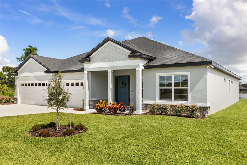 A single-story house with a gray exterior, a two-car garage, and a covered front porch — 14 STATICE COURT, HOMOSASSA, FL