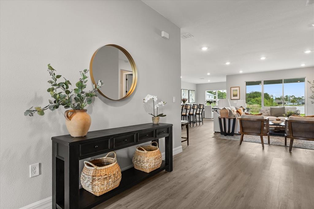 A black console table with baskets sits in a foyer leading to an open living area — 14 STATICE COURT, HOMOSASSA, FL