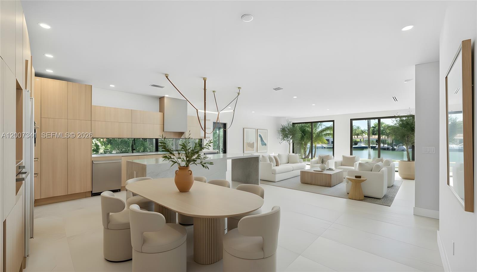 A modern open-concept kitchen, dining area, and living room with light wood cabinetry and views — 550 S Shore Dr, Miami Beach FL 33141, MIAMI BEACH, FL