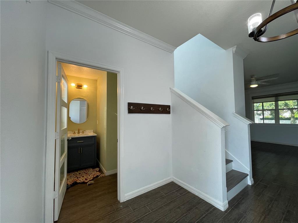 A foyer features wood-look tile flooring, a coat rack, a staircase, and a half bathroom — 4501 BALER TRAILS DRIVE, ST CLOUD, FL
