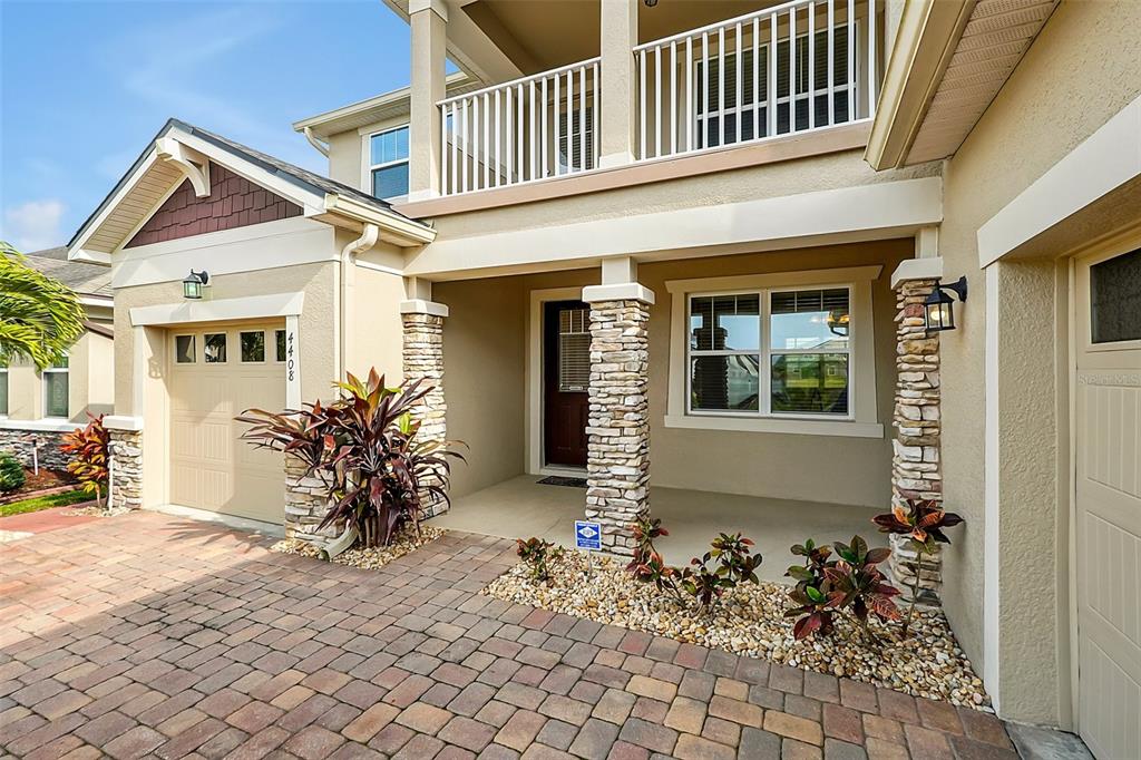A covered porch features two dark brown doors and a window with white trim — 4408 BREEZE ISLE LANE, KISSIMMEE, FL