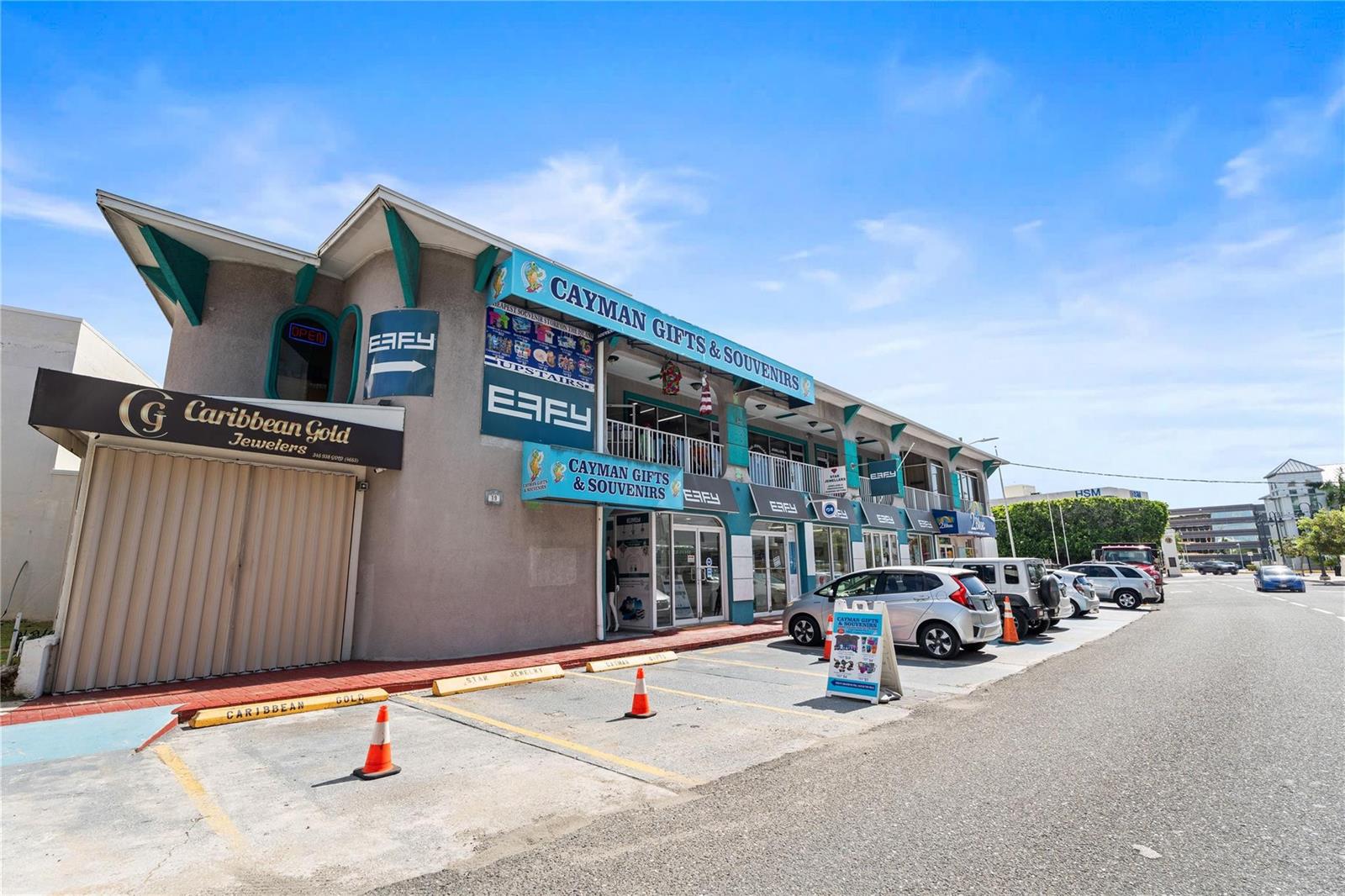 A two-story commercial building with retail storefronts and a parking lot in front — 19 Fort Street, GC, FL