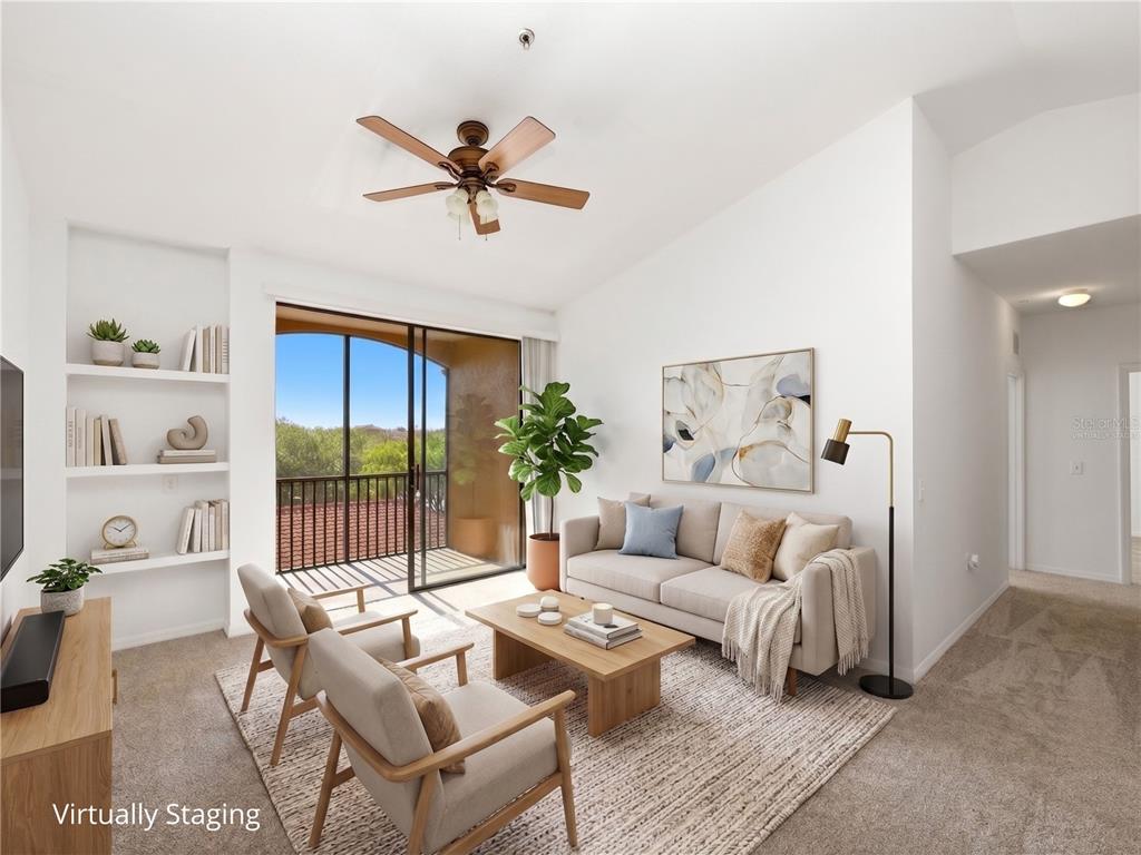 A living room with a ceiling fan, built-in shelving, and a balcony with outdoor views — 6169 METROWEST BOULEVARD UNIT 305, ORLANDO, FL