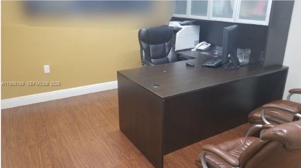 An office space features a dark wood desk, a black chair, and two brown chairs — 1701 W 37th St # 15, Hialeah FL 33012, HIALEAH, FL