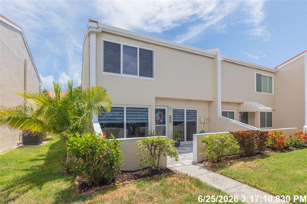 A two-story townhouse exterior with a small front patio, palm tree, and landscaped garden — 4207 FOGCUTTER COURT, TAMPA, FL