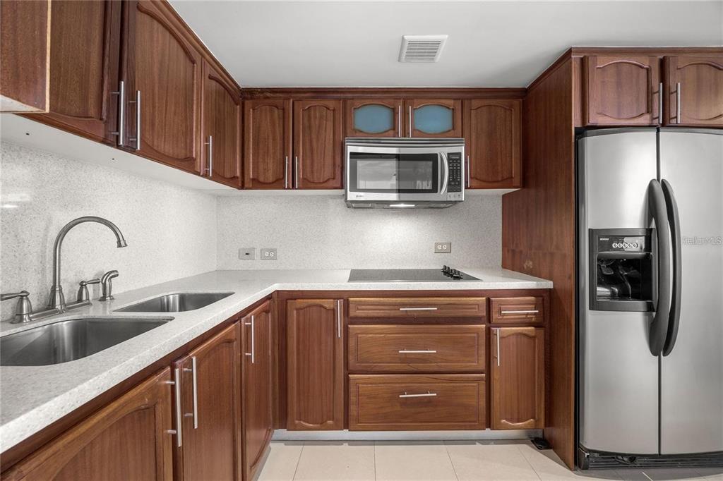A kitchen features wood cabinets, stainless steel appliances, a double sink, and white countertops — 14 CALLE MARSEILLES UNIT 3D, SAN JUAN, PR