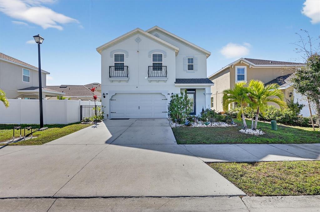 A two-story house with a white stucco exterior, a two-car garage, and a concrete driveway — 4842 SAN PALERMO DRIVE, BRADENTON, FL