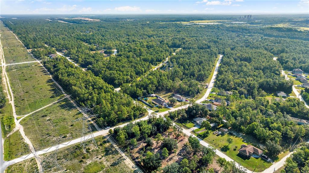 An aerial view shows a rural residential area with houses surrounded by dense forest — 0 CONDOR ROAD, BROOKSVILLE, FL