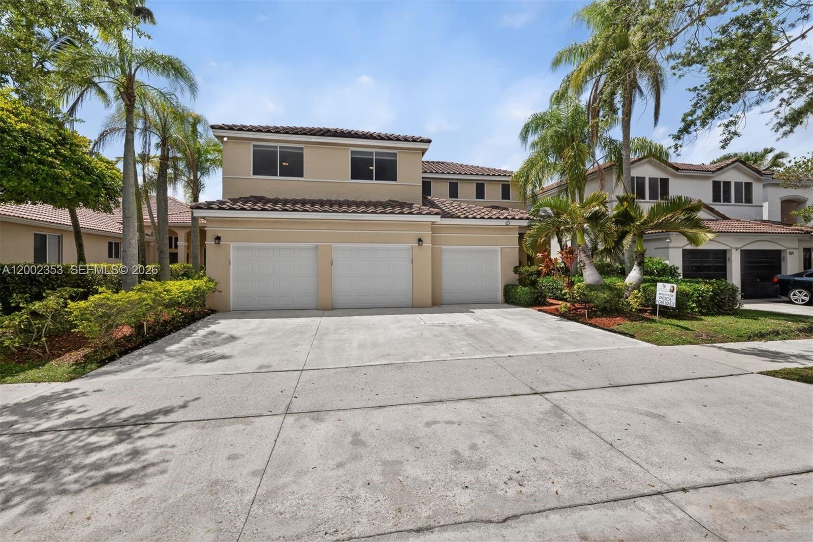 A two-story house with a three-car garage and a concrete driveway — 1115 Camellia Cir, Weston FL 33326, WESTON, FL