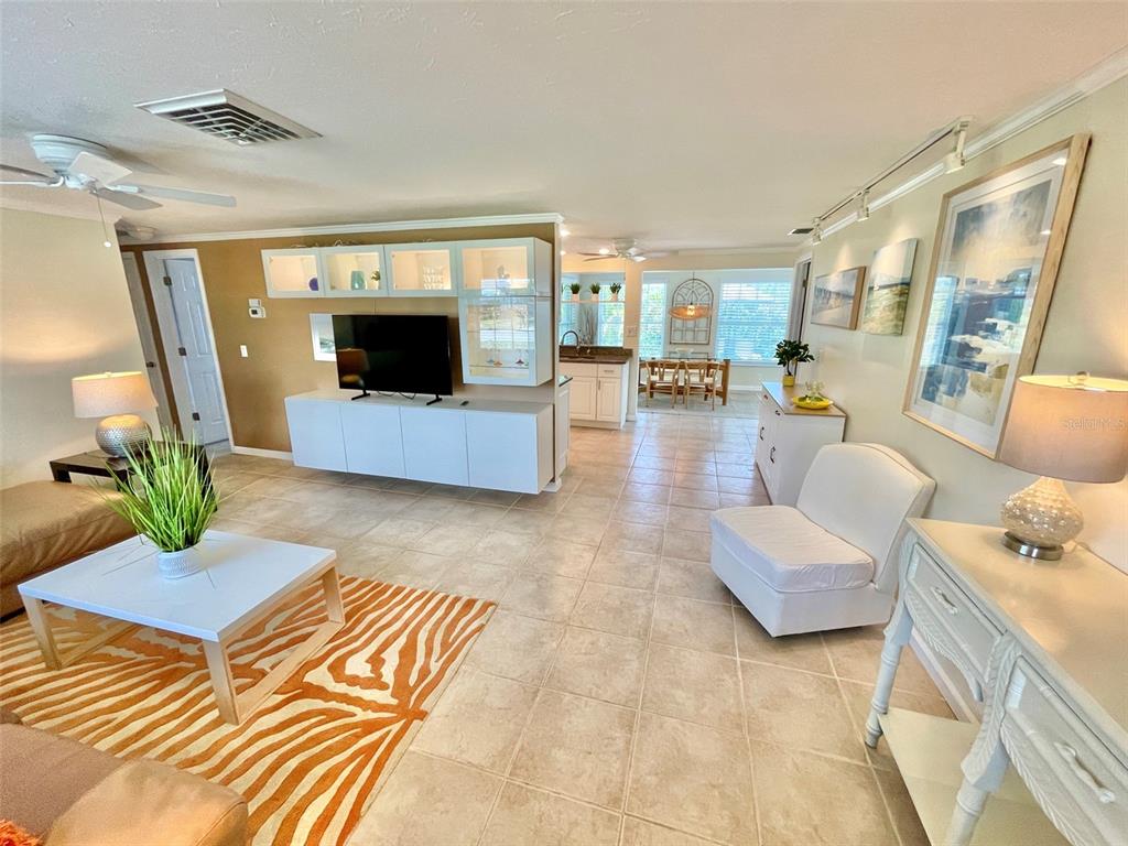 A living room features tile flooring, a white media console, and an adjacent dining area — 5240 DREW ROAD, VENICE, FL