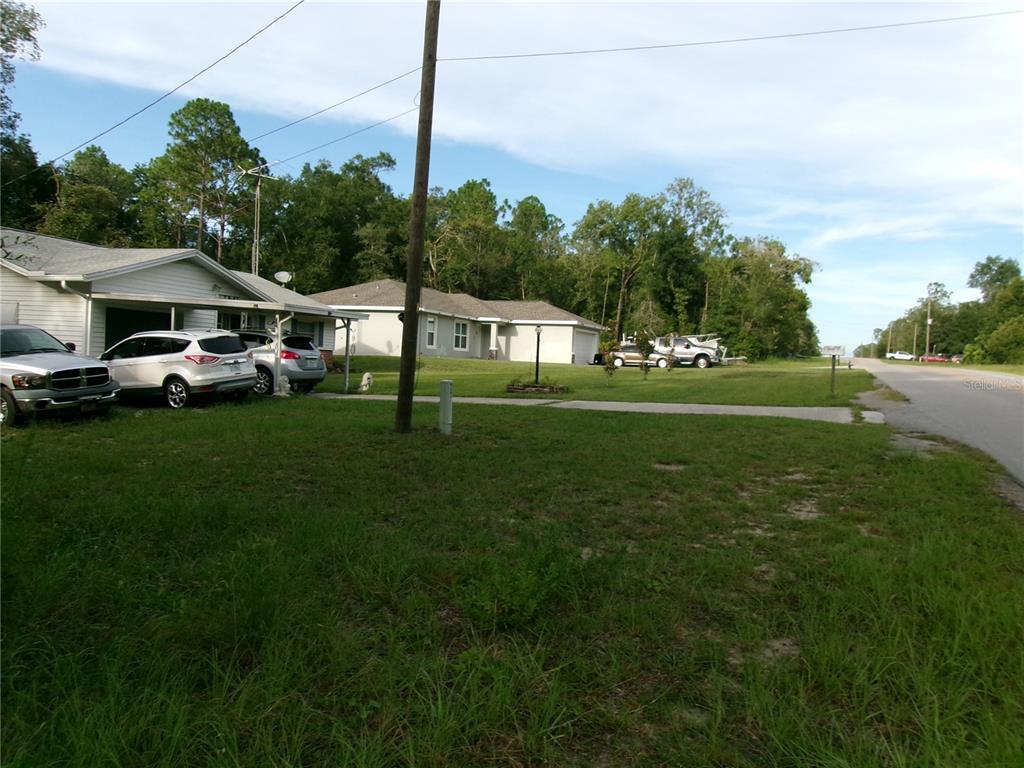 A residential street view shows two single-story houses with driveways and parked vehicles — LOT 20 SW RAINBOW LAKES BOULEVARD, DUNNELLON, FL