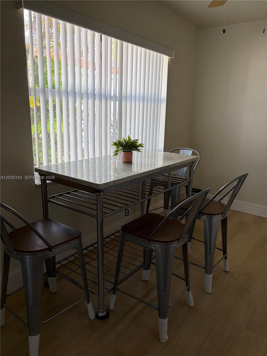 A living room features a dark leather lounge chair, a television console, and sliding glass doors — 1635 Dewey St # B, Hollywood FL 33020, HOLLYWOOD, FL