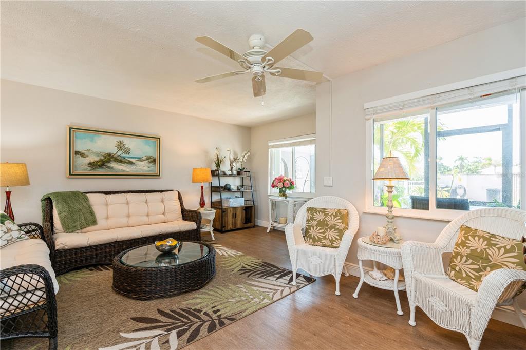 A living room features wicker furniture, a patterned area rug, and a ceiling fan — 527 CAPE CORAL PARKWAY W UNIT 4, CAPE CORAL, FL