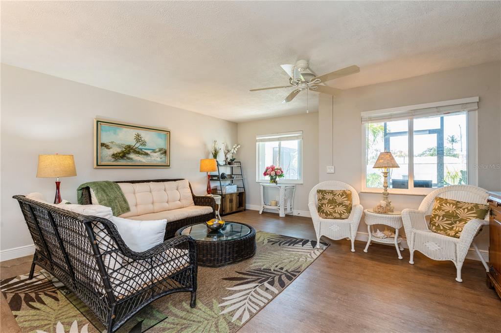A living room features wicker furniture, a patterned area rug, and two windows — 527 CAPE CORAL PARKWAY W UNIT 4, CAPE CORAL, FL