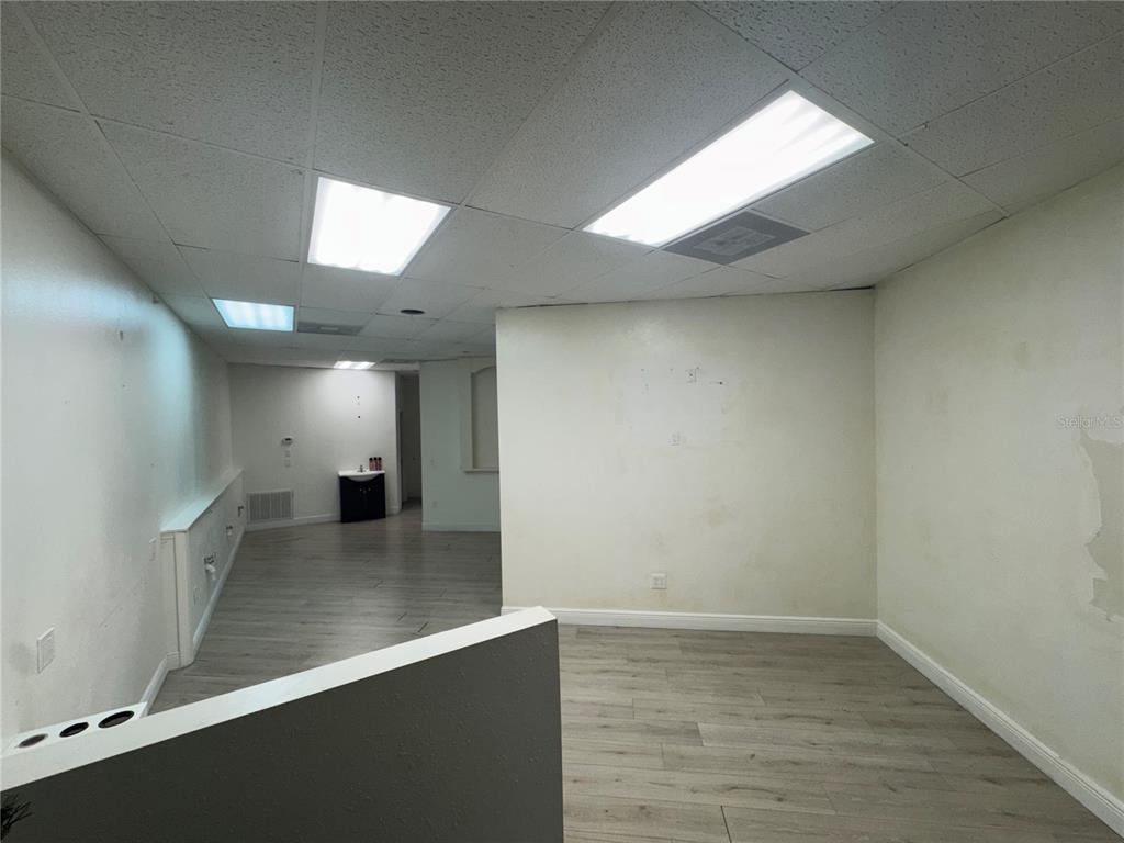 An interior view of an empty office space with light wood-look flooring and drop ceilings — 3274 COMMERCIAL WAY, SPRING HILL, FL