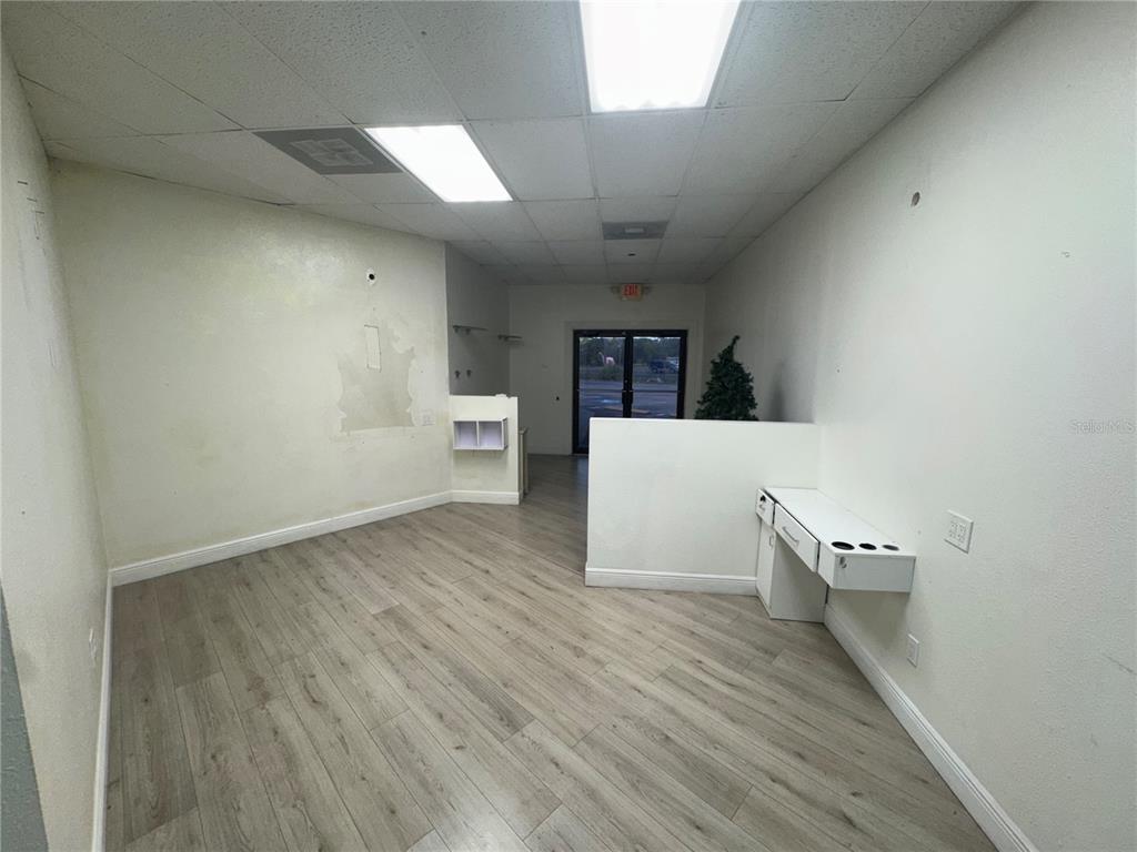 An interior view of a commercial space with wood-look flooring, white walls, and drop ceilings — 3274 COMMERCIAL WAY, SPRING HILL, FL