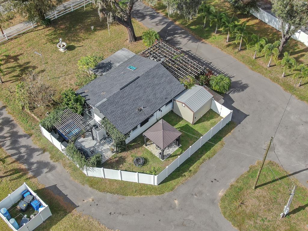 An aerial view shows a house with a fenced yard, a gazebo, and a shed — 105 S SAINT CLOUD AVENUE, VALRICO, FL