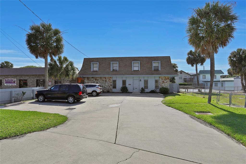 A two-story building with a stone facade and a parking lot in front — 162 S PENINSULA DRIVE, DAYTONA BEACH, FL