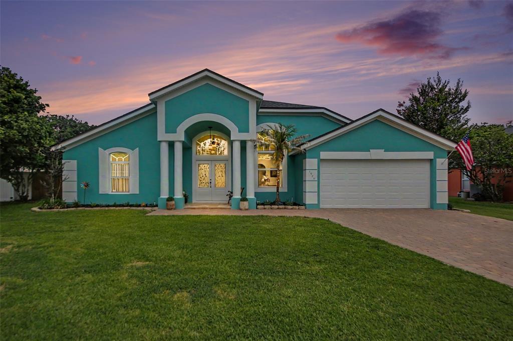 A single-story teal house with a two-car garage and a prominent arched entryway — 1986 CRYSTAL DOWNS COURT, OVIEDO, FL