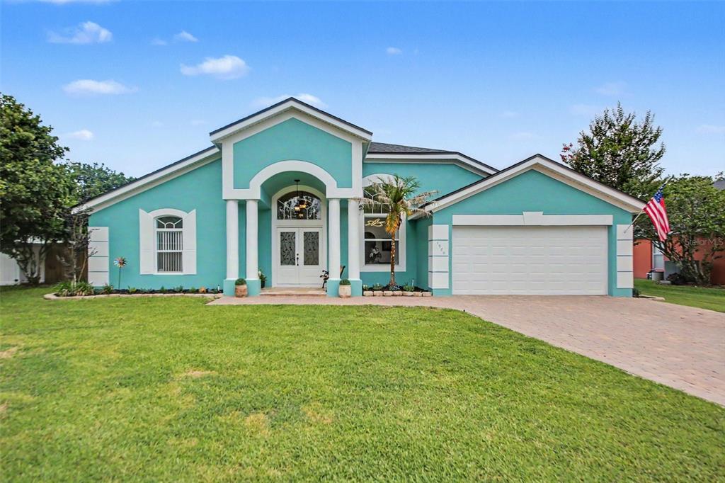 A single-story teal house with a white garage, arched entryway, and a front lawn — 1986 CRYSTAL DOWNS COURT, OVIEDO, FL