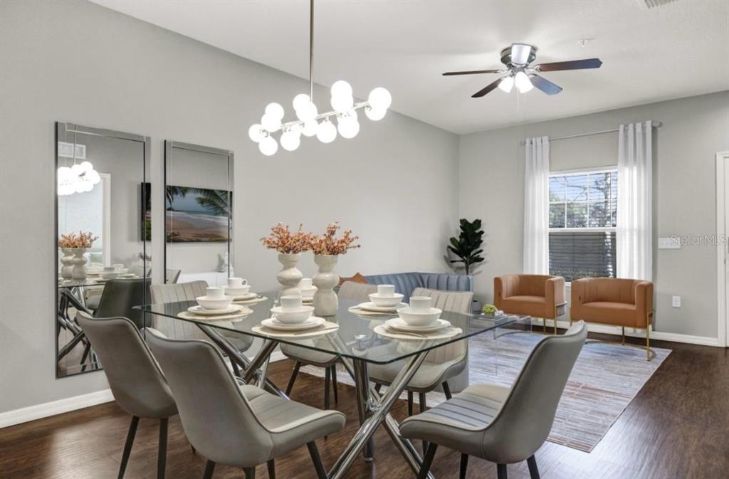 A dining room features a glass table, gray chairs, a modern chandelier, and two mirrors — 3202 GUANA WAY, KISSIMMEE, FL