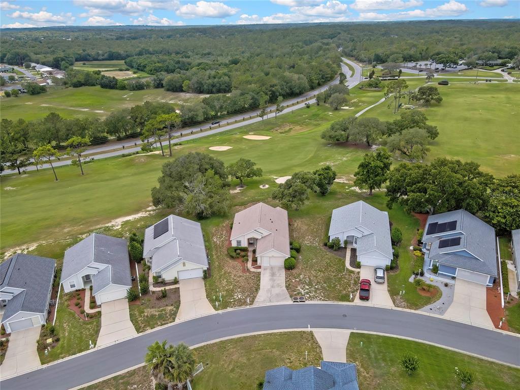 An aerial view shows a row of suburban houses bordering a golf course and road — 547 W HILLWOOD PATH, BEVERLY HILLS, FL