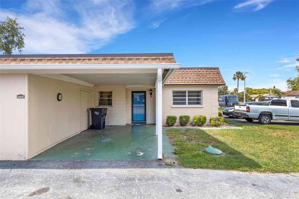 A single-story house features a carport, a front door, and a small patch of lawn — 4602 PARK ACRES DRIVE UNIT 96, BRADENTON, FL
