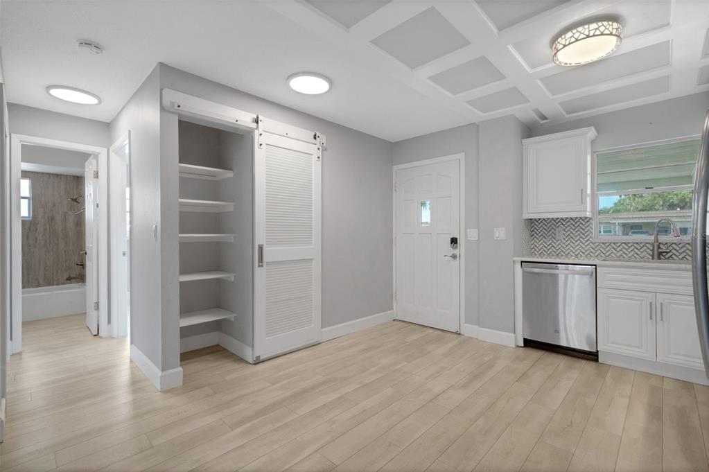 A kitchen with light wood floors, a sliding barn door pantry, and white cabinetry — 4602 PARK ACRES DRIVE UNIT 96, BRADENTON, FL