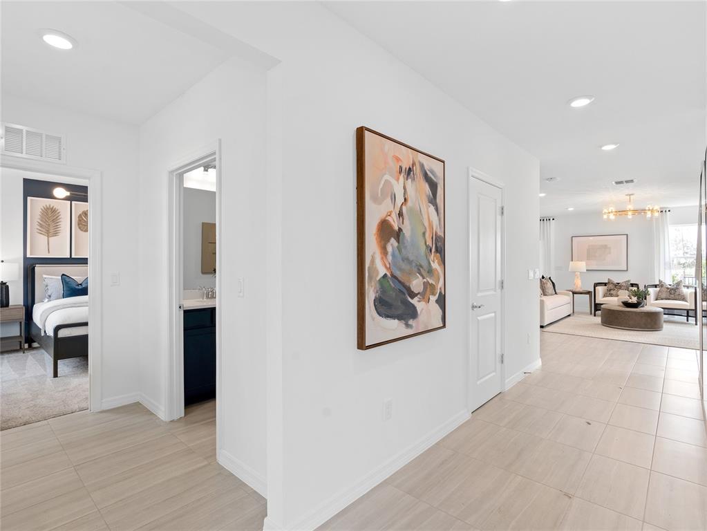 A hallway with light tile flooring leads to a living area and two side rooms — 10704 LEAFY LAUREL STREET, ORLANDO, FL