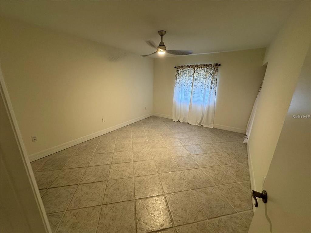 An empty room with beige walls, a ceiling fan, and light-colored tile flooring — 2275 S MCCALL ROAD UNIT 201, ENGLEWOOD, FL