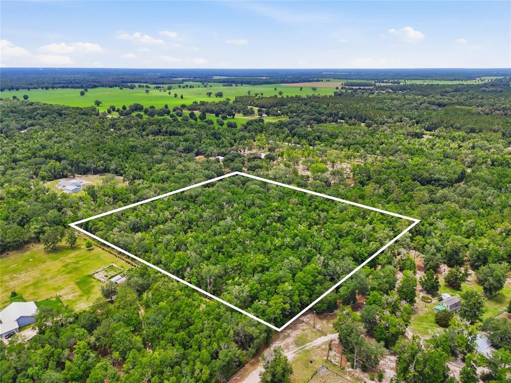An aerial view shows a rectangular plot of land outlined in white amidst dense forest — 00 SW SQUIRREL COURT, FORT WHITE, FL