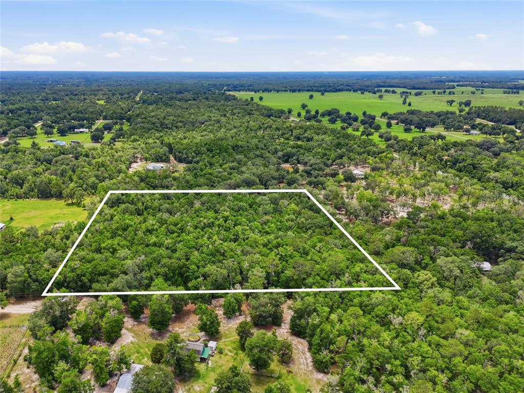 An aerial view shows a rectangular plot of land outlined in white amidst dense forest — 00 SW SQUIRREL COURT, FORT WHITE, FL