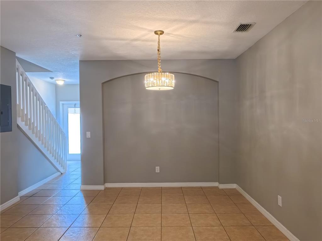 A dining area with a crystal chandelier, arched wall niche, and tiled flooring — 13349 HARBOR SHORE LANE, WINTER GARDEN, FL