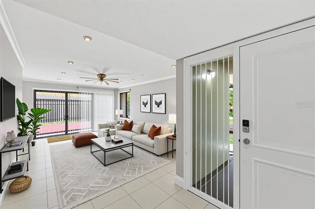 A bright living room features light tile floors, a white sofa, and a glass-paneled door — 8741 CLEARY BOULEVARD, FORT LAUDERDALE, FL