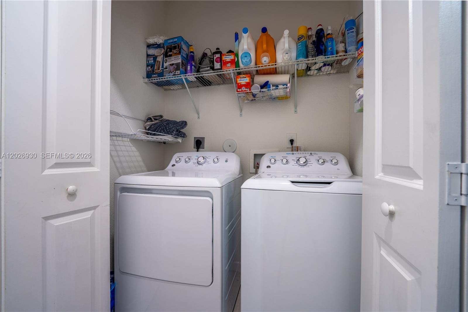 A laundry closet contains a white washer and dryer with wire shelving above — 2588 SE 2nd St, Homestead FL 33033, HOMESTEAD, FL