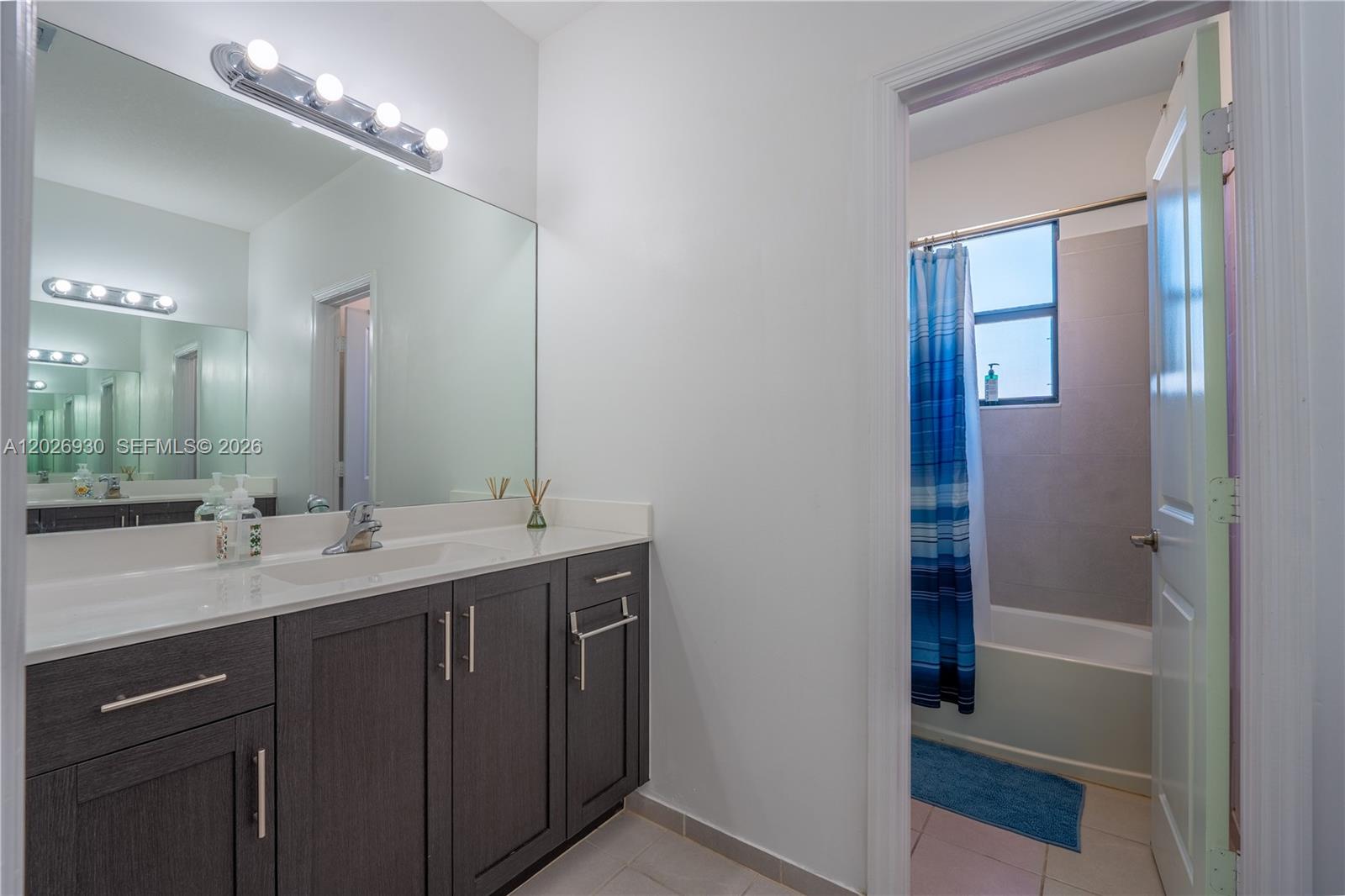 A bathroom features a dark wood vanity with a white countertop and a shower-tub combo — 2588 SE 2nd St, Homestead FL 33033, HOMESTEAD, FL