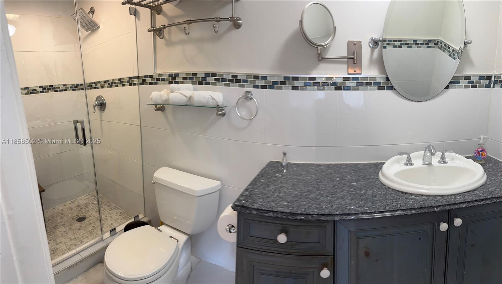 A bathroom features a glass-enclosed shower, a toilet, and a vanity with a granite countertop — 1301 Grouper Dr # A, Marathon FL 33050, MARATHON, FL