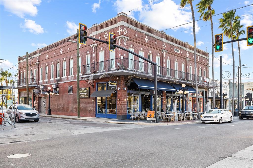A brick corner building features a restaurant with outdoor seating and a second-story balcony — 1829 E 7TH AVENUE, TAMPA, FL
