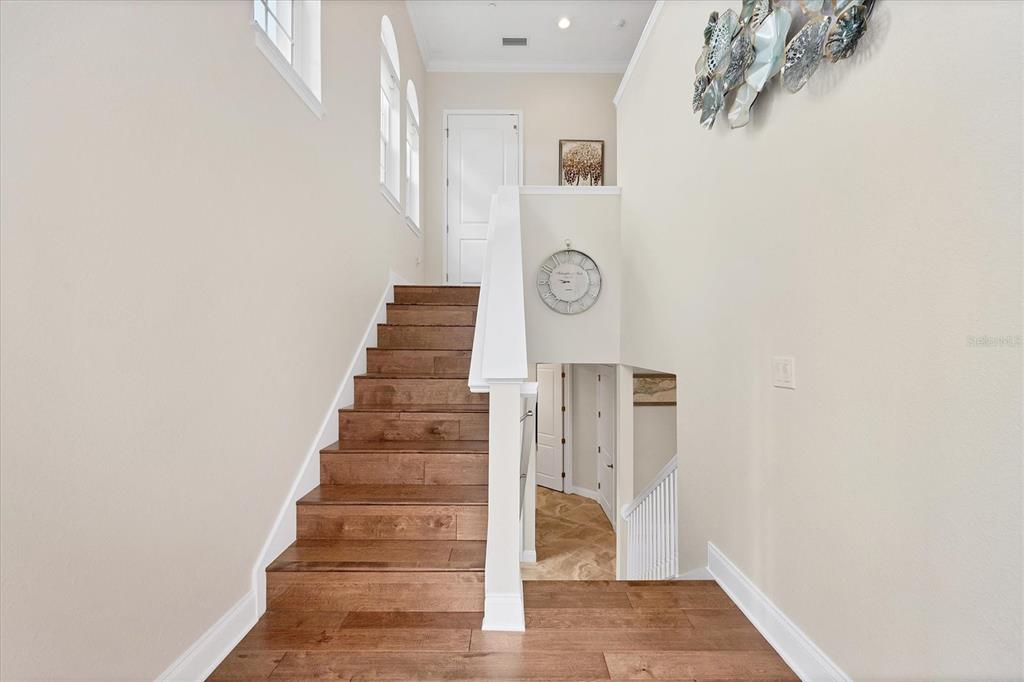 A staircase with wooden treads leads to an upper landing with a white door — 455 NOKOMIS AVENUE S UNIT 455, VENICE, FL