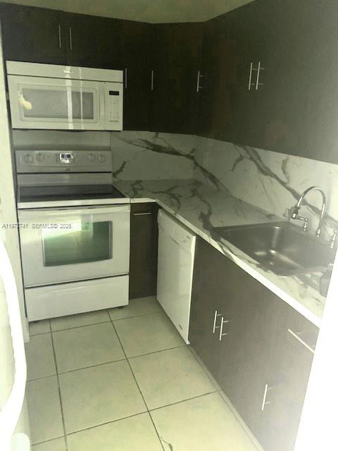 A kitchen features dark cabinets, white appliances, and marble-patterned countertops with a stainless steel sink — 13714 SW 90th Ave # 25, Miami FL 33176, MIAMI, FL